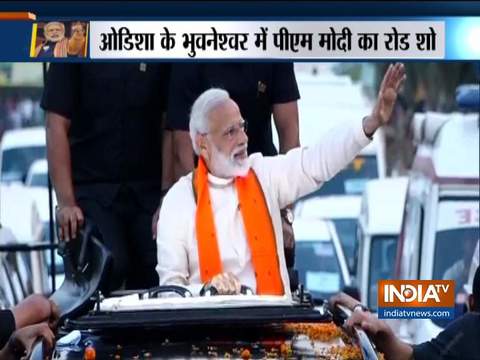 PM Modi waves to people on his way to Baramunda ground, Bhubaneswar